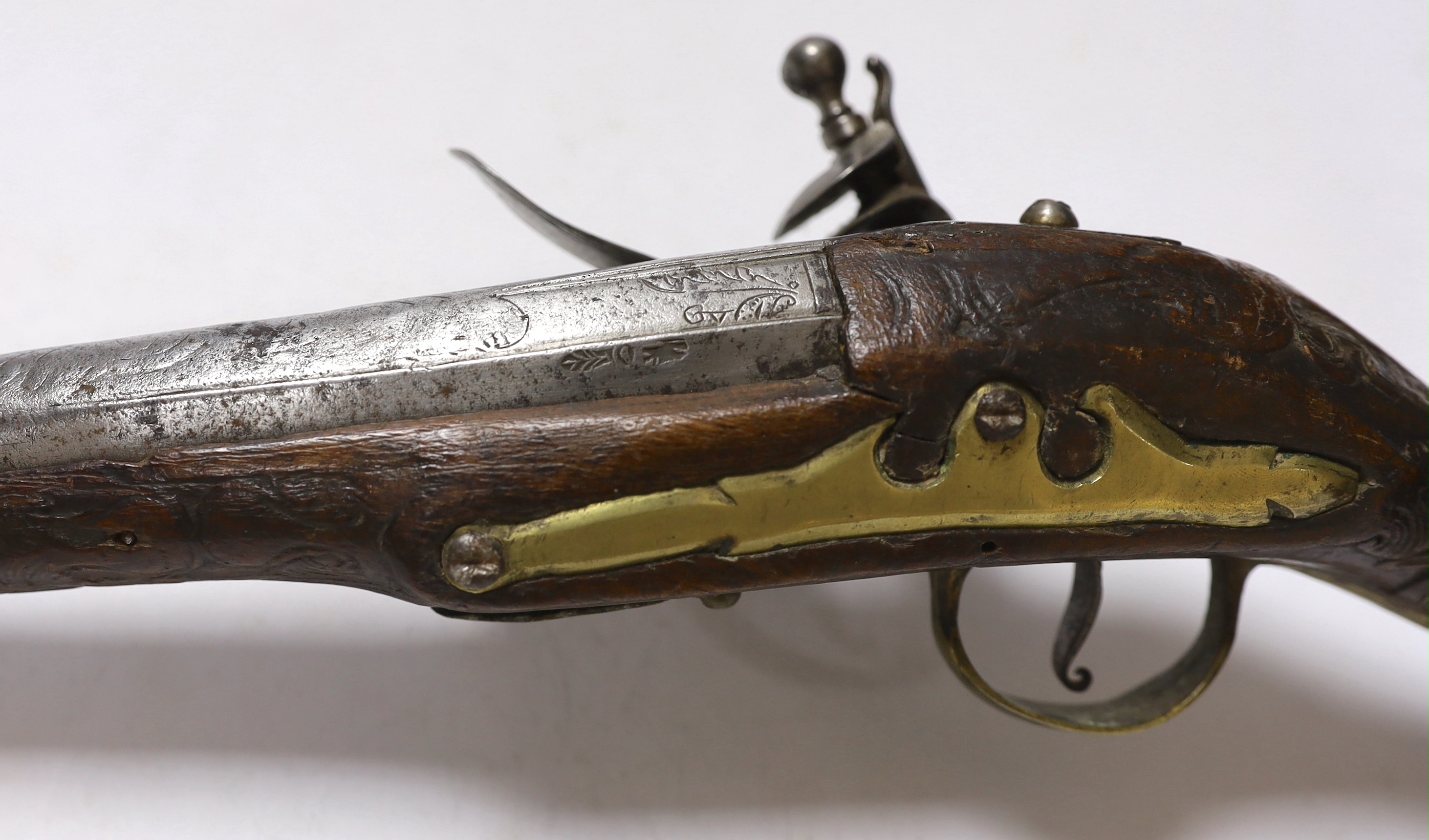 A Turkish Flintlock holster pistol with brass mounts, long spur butt cap, engraved lock and carved stock, barrel 29.5cm